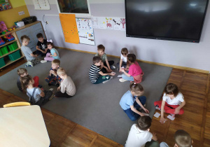 Na zdjęciu widać dzieci pogrupowane w 4 drużyny, które grają w grę matematyczną.