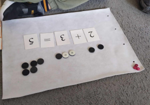 Dzieci wykonują proste działania matematyczne w oparciu o liczmany.