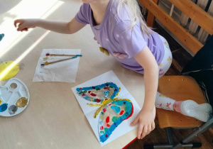 Dziewczynka maluje motyla.