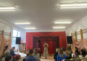 Na zdjęciu widzimy Panią Dyrektor Szkoły Podstawowej nr 8 im. Jana Brzechwy w Bełchatowie witającą przybyłych gości oraz solistów biorących udział w konkursie wokalnym.