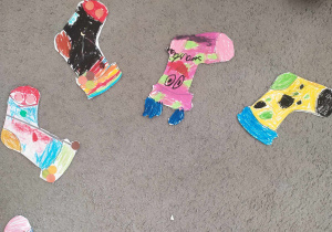 Zdjęcie prac dzieci – kolorowe skarpetki pomalowane kredkami pastelowymi.