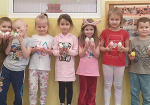 Dzieci z grupy Słoneczka prezentują ozdobione pisanki.