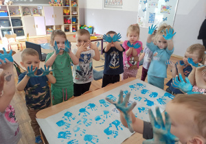 Dzieci z grupy Biedronki wspólnie wykonują plakat na Światowy Dzień Autyzmu