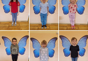 Dzieci z grupy Odkrywcy pozują do zdjęcia na tle skrzydeł motyla.