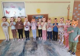 Dzieci z grupy Słoneczka przymierzają do twarzy maski i zmieniają się w gepardy.