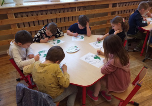 Dzieci malują farbami kontur Ziemi.