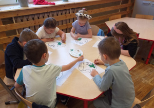 Dzieci z grupy Tropiciele malują farbami kontur Ziemi.