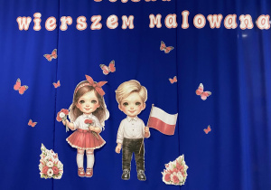 1.Tablica demonstracyjna przedstawiająca napis: ,,Polska wierszem malowana” oraz chłopca i dziewczynkę ubranych w stroje w barwach narodowych.