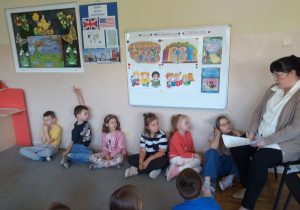 Dzieci z grupy Tropiciele słuchają pani bibliotekarki opowiadającej o swoim zawodzie.