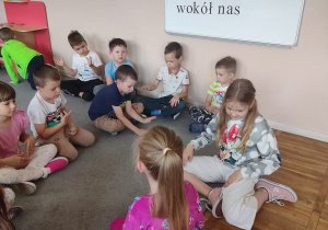 Dzieci z grupy Tropiciele słuchają piosenki o Dinku.