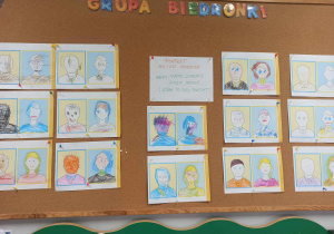 Portrety rodziców wykonane przez dzieci, wywieszone na tablicy z pracami plastycznymi grupy Biedronki.