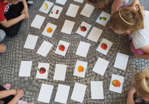 Dzieci grają w grę „Memory - Owoce”.