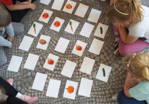 Dzieci grają w grę „Memory - Warzywa”.