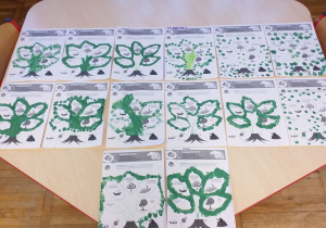 Prace plastyczne dzieci - drzewa z liśćmi namalowanymi za pomocą paluszków maczanych z zielonej farbie.