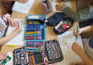 Dzieci dekorują napis „English” za pomocą kredek i mazaków.