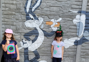 Dwie dziewczynki pozują do zdjęcia z obrazkiem Królika Bugsa.