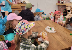 Dzieci z grupy Motylki siedzą przy stoliku i jedzą drugie śniadanie.
