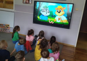 Misja łąka i pola. Dzieci z grupy Pszczółki oglądają bajkę edukacyjna "Na łące".