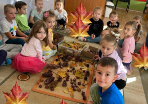 Dzieci z grupy Misie pozują do zdjęcia z wykonanym przez siebie sensorycznym obrazem.