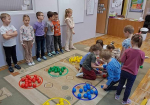 Część dzieci skończyła segregować piłeczki, a druga kończy.