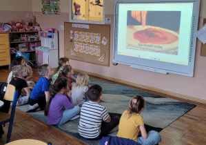 Smerfy oglądają filmik edukacyjny o pizzy.