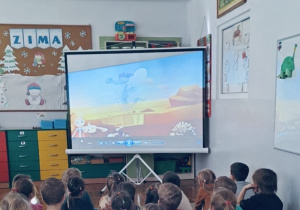 Cała grupa ogląda film edukacyjny dotyczący zawodu paleontologa.