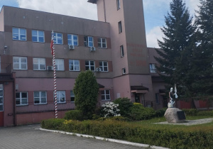 Budynek PSP w Bełchatowie, a przed nim patron strażaków św. Florian.