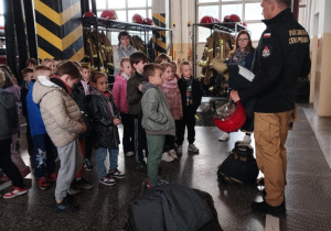 W ważnej części budynku straży, czyli garażu , strażak zapoznaje przedszkolaków z pracą którą wykonują strażacy wykorzystując do tego różnorodny sprzęt.