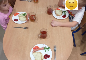 Dzieci zajadają pyszne kiełbaski - ulubioną potrawę Niemców.
