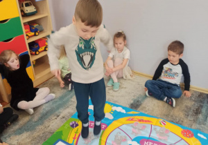 Chłopiec z grupy „Słoneczka” skacze po macie.