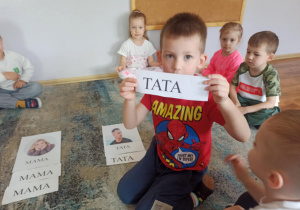 Chłopiec z grupy Słoneczka” segreguje napisy Mama i Tata.