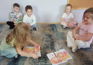 Dziewczynki z grupy „Słoneczka” układają puzzle z wizerunkiem mamy.
