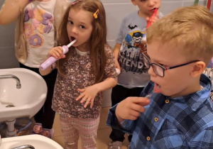 Dzieci w łazience myją zęby.