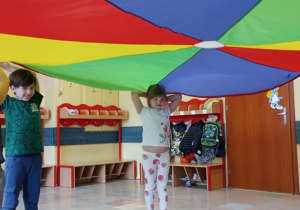 Dzieci chowają się pod chustę animacyjną.