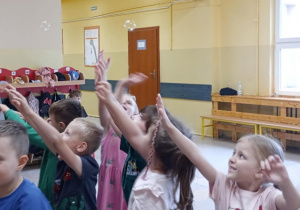 Dzieci w trakcie zabawy z bańkami mydlanymi.