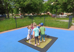 Dzieci z grupy „Słoneczka” skaczą na trampolinie.