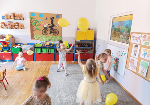 Zdjęcie przedstawia dzieci podczas zabawy z balonami.