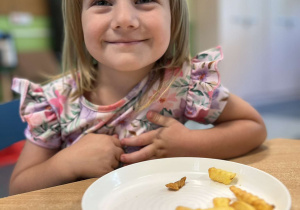 Dziewczynka degustuje frytki upieczone bez tłuszczu w Air Fryer