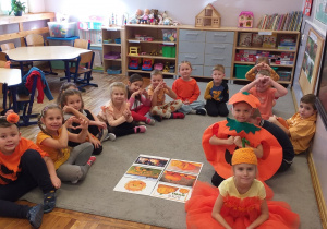 Zdjęcie przedstawia dzieci poznające cechy charakterystyczne dyni.