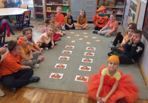 Zdjęcie przedstawia dzieci po przyporządkowaniu dyń do odpowiedniej liczby.