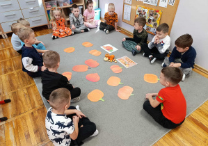 Dzieci z grupy „Misie” bawią się na dywanie w „Farmę Dyniową”.