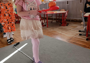 Dziewczynka z grupy „Misie” przechodzi po linie trzymając w ręku łyżkę na której umieszczona jest dynia.