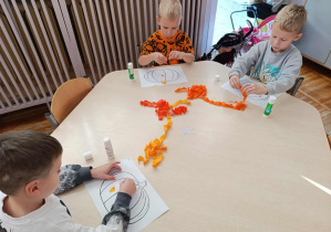 Dzieci z grupy „Misie” wykonują dynię z bibuły.