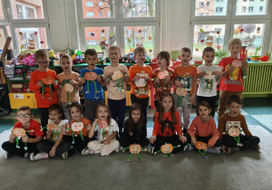 Motylki pozują do zdjęcia grupowego ze swoimi pracami.