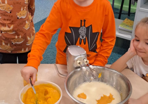 Chłopiec dodaje do miski mus z dyni.