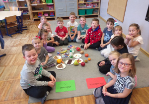 Zdjęcie przedstawia dzieci przed segregowaniem produktów zdrowych i niezdrowych.