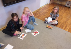 Zdjęcie przedstawia dzieci układające małe obrazki z puzzli.