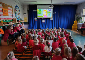 Trzylatki, czterolatki oraz pięciolatki podczas oglądania filmu edukacyjnego.