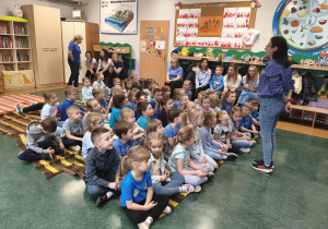 Dzieci sześcioletnie ubrane na niebiesko słuchają pogadanki przeprowadzonej przez pedagoga specjalnego.