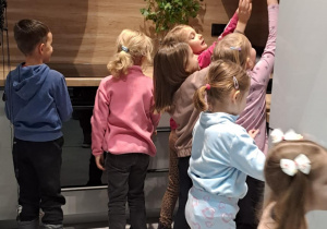 Dzieci oglądają meble kuchenne w sklepie.